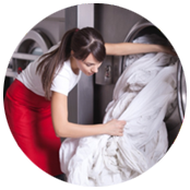 donna che inserisce lenzuoli in lavatrice